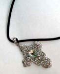 Religious jewelry distribution wholesaler supplying Fashion religious pendant in silver plated cross design with large emerald green cz gem at center.