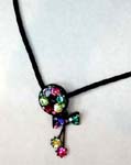 Crystal jewelry online catalog distributor supplies Multicolored cz gemstone pendant in a circle with bow tie design extending from bottom and two cz gems dangling below