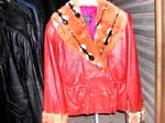 Jacket / coat manufacturing factory wholesales imitation leather products for retail sale. Red imitation leather jacket with brown faux fur design around cuffs and collar