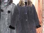 Wholesale export agent supplies fashion jackets and coats. Faux black suede mid length black coat with black roll up cuffs and brown imitation fur collar