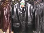 Mens  wholesale coats distruted for retail shops. Imitation, black leather evening jacket at mid length and has button up front