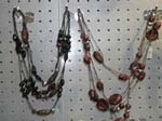 Seashell necklace products sold from import distribution company. Dark shell and stone necklace in a variety of sizes on dark cord string