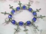 Designer charms distributed by China wholesale company. Stretchy charm bracelet with purple color beads and silver cross charms and flowery beads