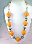 High quality fashion wholesale jewelry supplied by online wholesaler. Large, dark yellow beaded necklace with silver plated chain connecting each bead and changing to small blue, orange, red, and whote beads around neck.