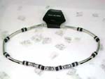 Wholesale jewelry supplier imports necklace designs. Silver necklace with solid pole chain attached with black beads. Center of necklace has three long silver designed beads interconnected with black beads