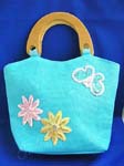 Designer canvas handbag distributors suply at discount price. Blue canvas fabric with sequins double wooden handle hand bag motif pink and yellow flowers with butterfly on right hand side in sparkle chips and thread work design, also zipper closure and inner zipper pocket
