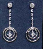 Online jewelry distribution import company supply cz earrings. Dangling double hooped earings with flower shaped figure plated in rhodium and clear cz stones along chain