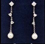 Wholesale wedding jewelry imported and distributed online. Three simulated diamonds hang along a chain on long earings holding imitation pearls..