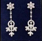 Accessory fashion wholesale company manufacturing beautiful jewelry. Cz embedded flower studs holding chains that attach to leaf design below circle.