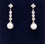 Display crystal jewelry wholesaler imports cz fashions. Imitation pearl held by three simulated diamonds hanging from a rhodim plated flower stud. 