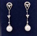 Direct factory jewelry wholesale company sells cz fashions. Imitation pearls suspended below two rhodium plated poles with floral patter between an above them. Arched stud contains cz stones..