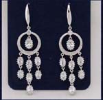 Wholesale earring fashions supplied by online import jewelry company. Star burst made of cz stones hang in the center and below rhodium plated hoop.