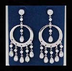 Jewelry stone store distributing wholesale earrings. Hoop earings with clear cz stone inlaid in sun bursts hanging beneath and in the center held up by another cz stone in stud. 