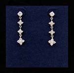 Women style pierced earring wholesaler distributes imported fashions. Three flowers with cz stone in center hang from rhodium plated chain