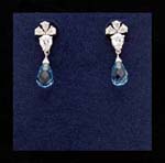 Blue topaz cz wholesale jewelry exported from China for retail sale. Translucent blue cz stones hang from clear cz chrystal which is held by three rhodium plated leaves