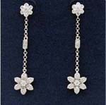 Jewelry import manufacturers distribute wholesale gemstone earrings for retail sale. Floral motif with large flower hanging at bottom and smaller one as stud, both contain a cz chrystal in the center. The chain connecting the two is rhodium plated and has a cz stone in the middle