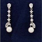 High fashion product supply manufacturers sell gemstone jewelry for retail sale. Imitation pearl dangling beneath three cz stones inlaid in rhodium plated chain with cz chrystal in stud and leaf design above pearl