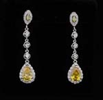 Fine wholesale jewelry import business distributes gemstone jewelry. Oval yellow cz stone surrounded by small clear cz chrystals as stud and larger one hanging beneath connected by a thodium plated chain with three cz chrystals.