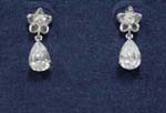 Wholesale gemstone womens fashion accessory sold online by import distributor. Fun earings with rhodium plated flower studs and oval cz crystal dangling beneath
