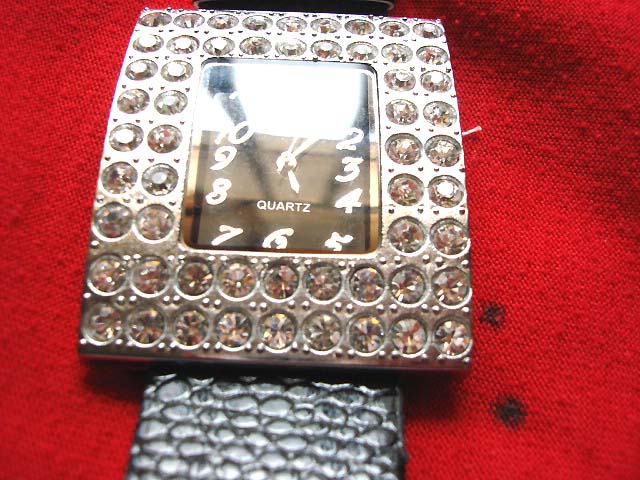 Large stone inlaid silver framed watch with black imitation leather strap. Jewellery retail supplier 