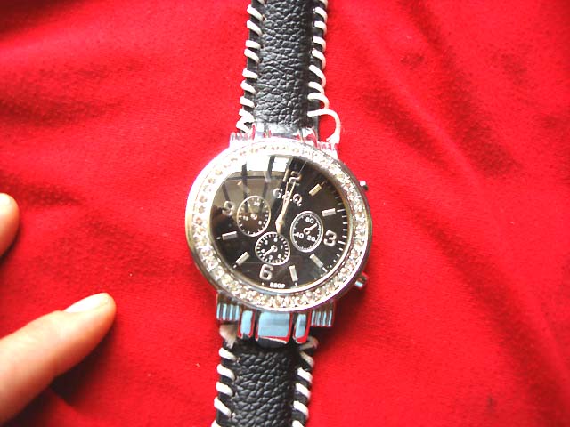 Black strap with white stitching holding classic kinetic style watch clock outsourcing supply dealer