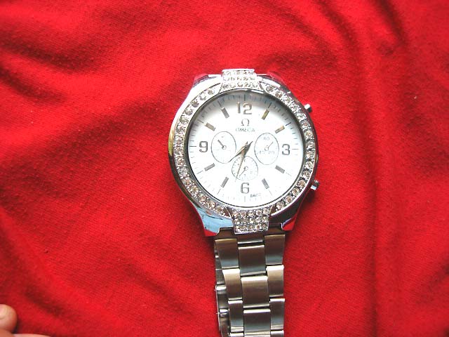 Gift boutique supplier - Mens silver chain link strap holding classic omega watch