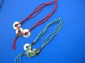 Triple sea shell circle pendant charms entwined in multi string bead necklace