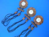 Indonesian flower motif pendant made from wood with mother of pearl sea shell in center dangling from multi, black string necklace with wooden beads