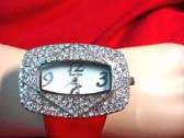 Rectangular shaped, large frame wrist watch with imitation diamonds in frame and red strap