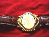 New age G & Q designed watch with gold colored oval frame and burgundy, imitation leather strap