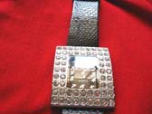 Fine, silver rectangular framed watch face with stones inlaid and black imitation leather strap
