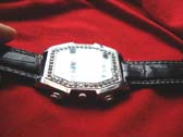 Black imitation leather strap holding silver framed vintage style watch