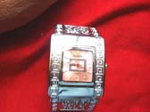 Spiral design along sides on silver framed bangle bracelet watch