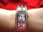 Silver bangle bracelet watch with center lined stones and small gems lining sides