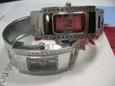 Metallic wear silver watch with G letter on bangle bracelet and square spiral theme on frame of clock face