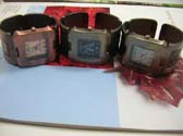 Capital lettering motif on wide bangle bracelet watch with squared clock face