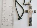 Fashion necklace with black twisted cord string holding a cross mental pendant with black enamel at edges